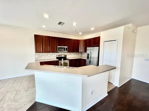 a kitchen with granite countertop a stove top oven microwave and cabinets
