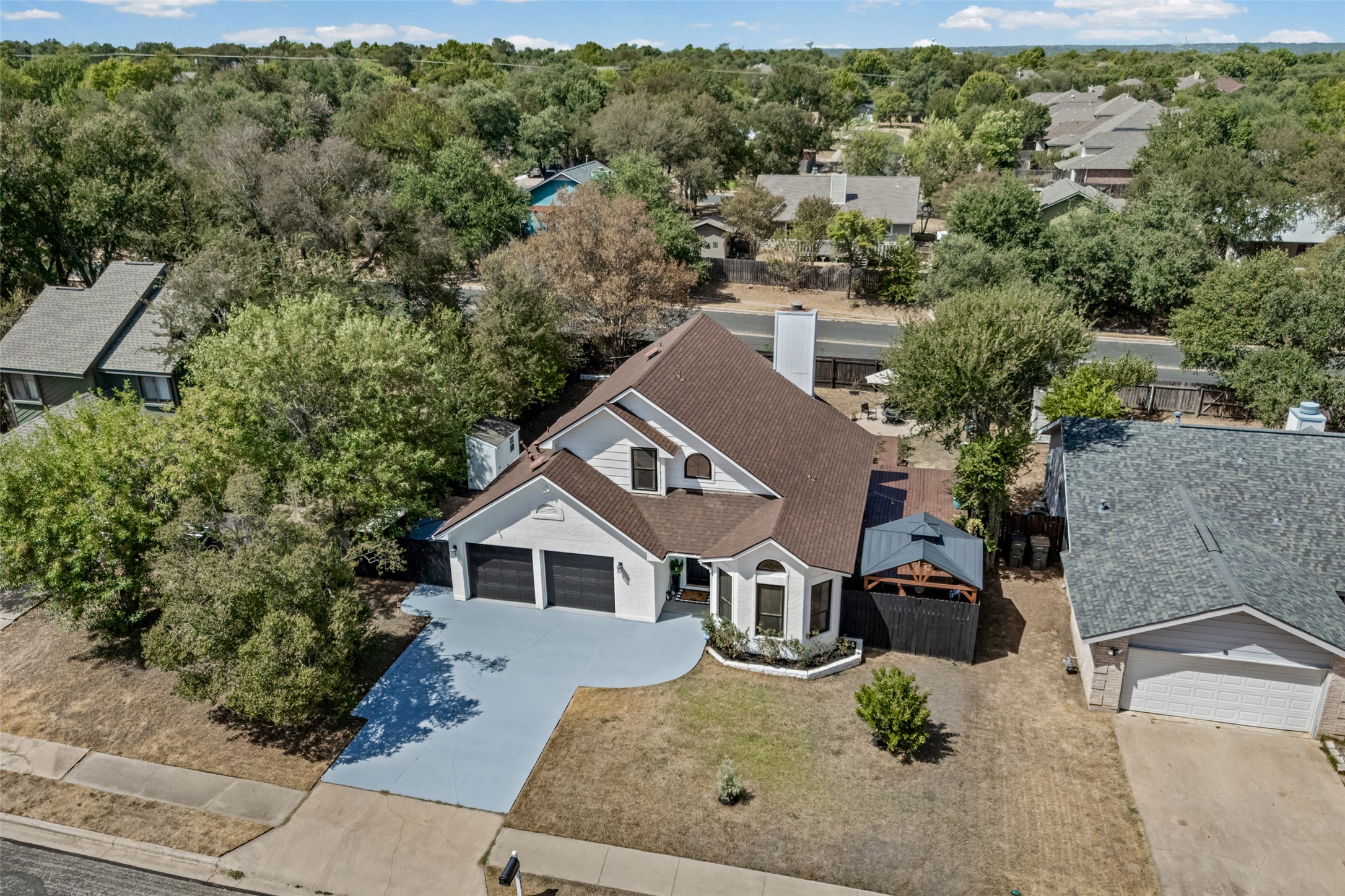 3006 Overland Street Round Rock, TX 78681 - Photo 26 of 29 Mature trees frame a classic multistory exterior with an attached two-car garage and paved driveway.