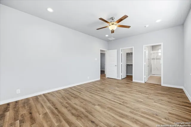 an empty room with closet and ceiling fan