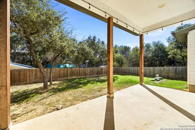 a view of a backyard with wooden fence