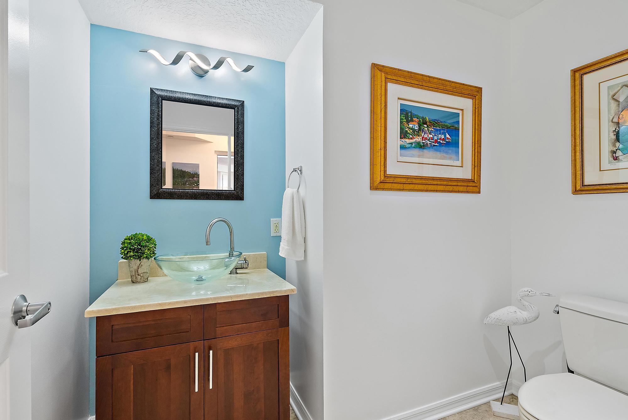 314 Inlet Way, Unit 103 Palm Beach Shores, FL 33404 - Photo 12 of 20 a bathroom with a toilet sink and mirror