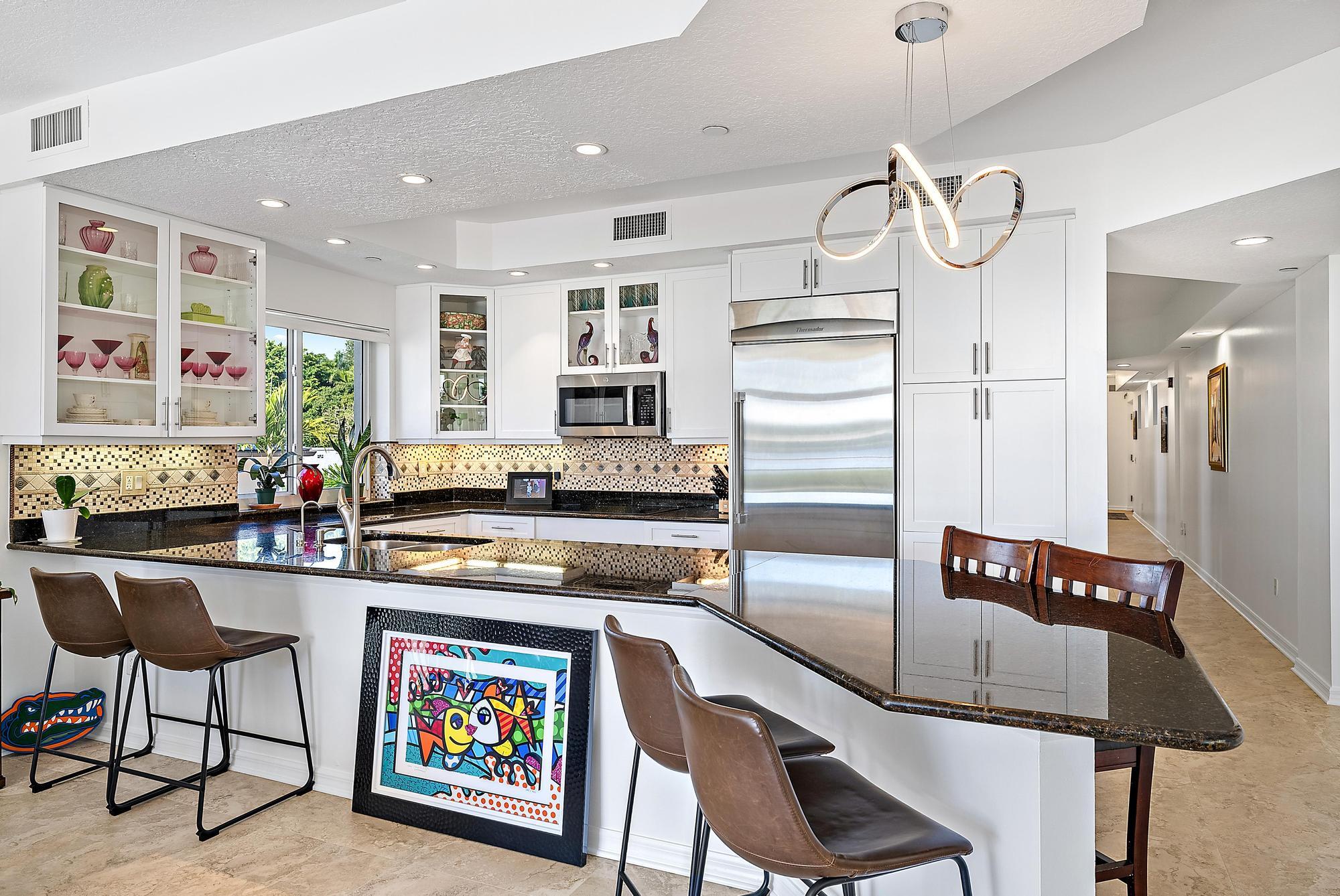 314 Inlet Way, Unit 103 Palm Beach Shores, FL 33404 - Photo 17 of 20 a kitchen with stainless steel appliances granite countertop a refrigerator and a stove top oven