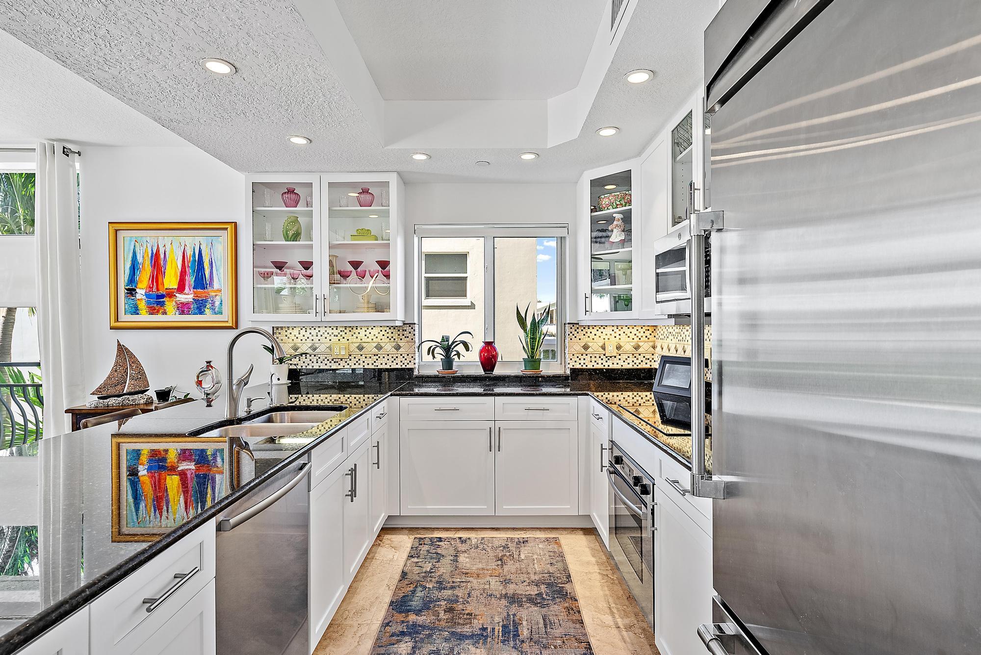 314 Inlet Way, Unit 103 Palm Beach Shores, FL 33404 - Photo 18 of 20 a kitchen with stainless steel appliances granite countertop a stove and cabinets