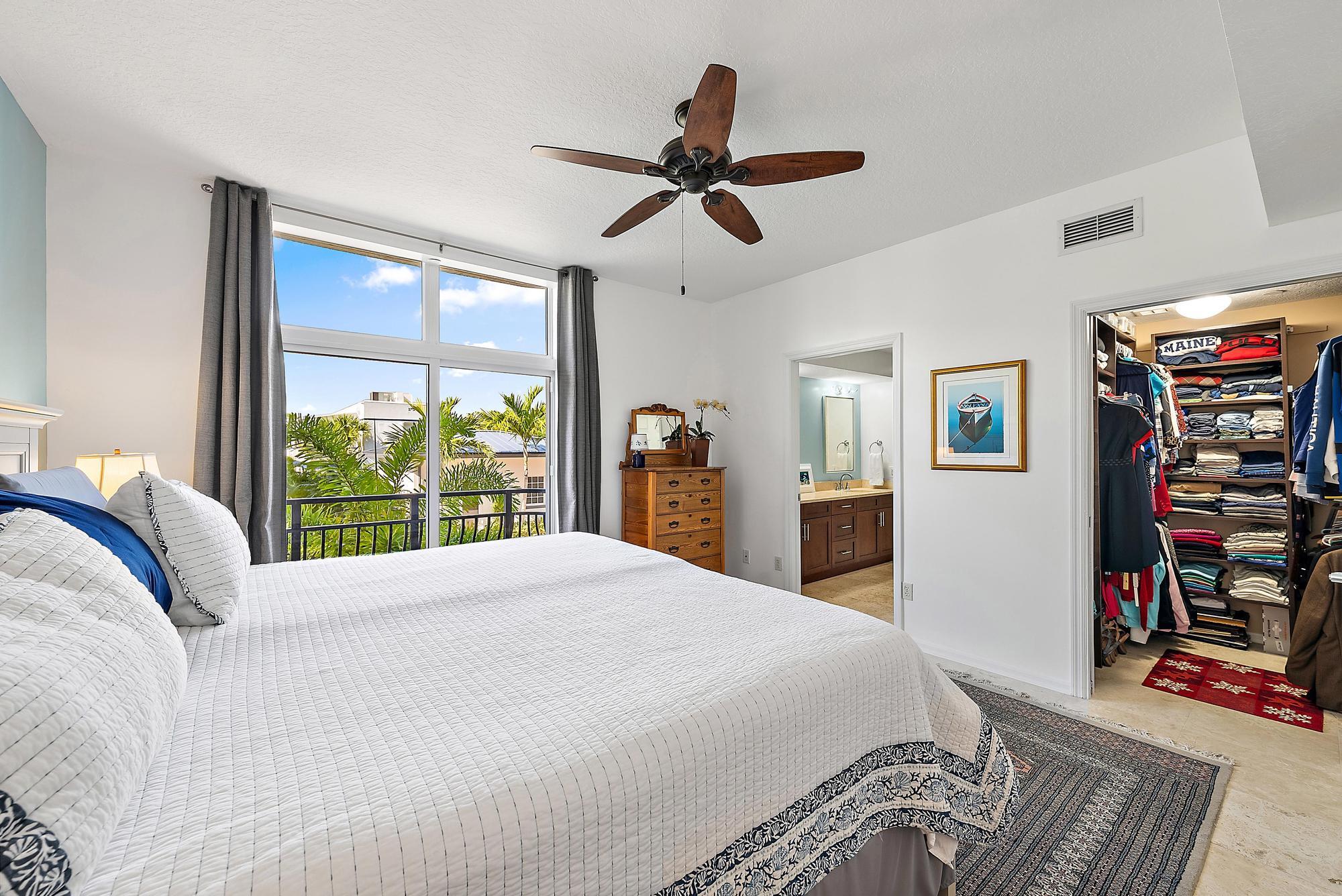 314 Inlet Way, Unit 103 Palm Beach Shores, FL 33404 - Photo 9 of 20 a bedroom with a bed dresser and a large window