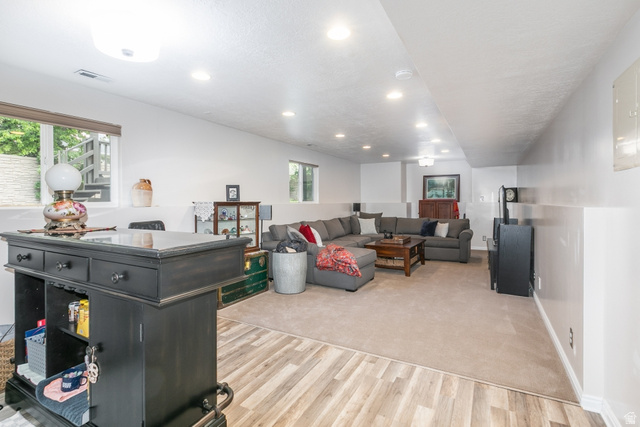10183 Hickory Point Drive Sandy, UT 84092 - Photo 23 of 36 Lower-level entertainment space featuring a combination of wood-finish flooring and carpeting