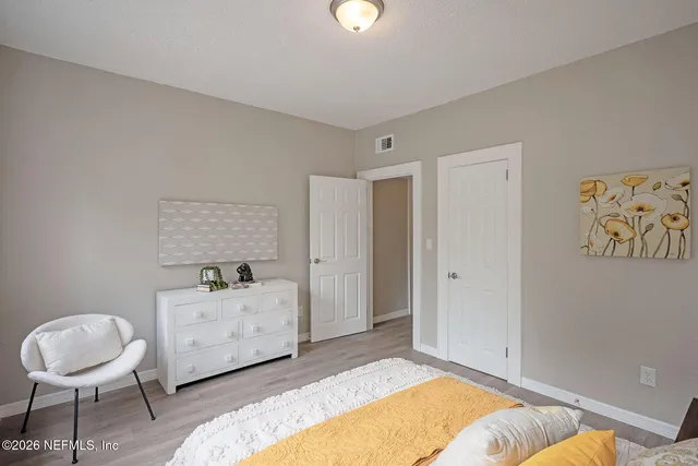 a spacious bedroom with a bed and a chair