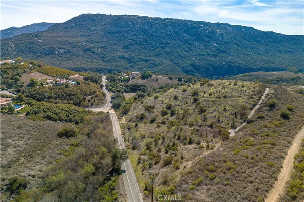 a view of a dry field with mountains in the background