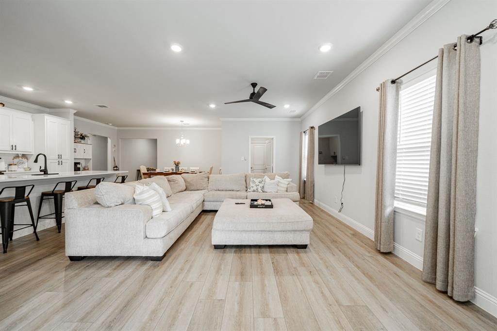 248 Waters Rdg Drive Lavon, TX 75166 - Photo 17 of 36 Living area featuring crown molding, a ceiling fan, light wood-style floors, and suspended lighting