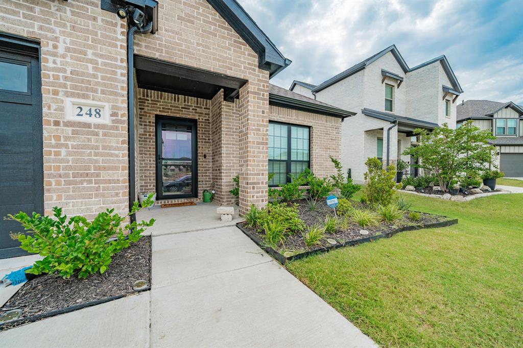 248 Waters Rdg Drive Lavon, TX 75166 - Photo 2 of 36 Doorway to property featuring brick siding and a lawn