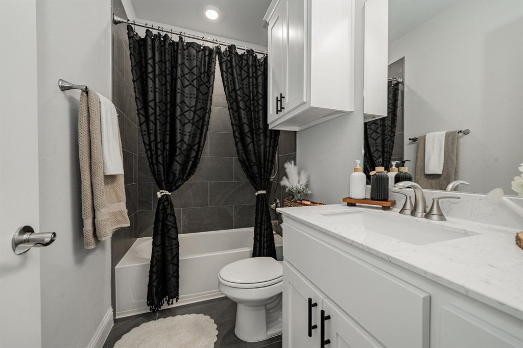 248 Waters Rdg Drive Lavon, TX 75166 - Photo 26 of 36 Bathroom featuring vanity, shower / bath combo, and dark tile patterned floors