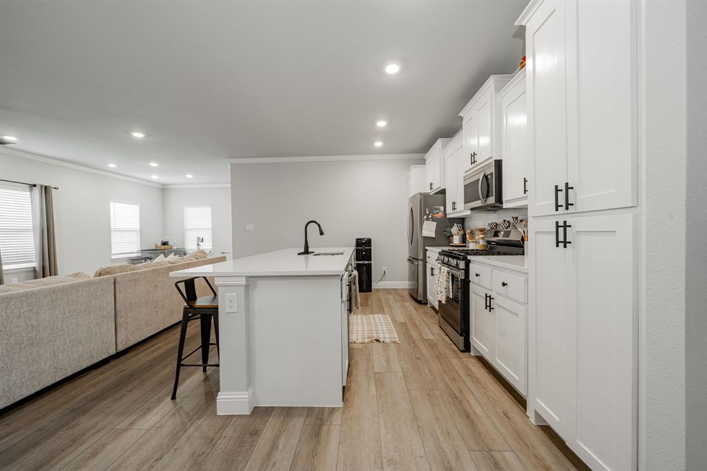 248 Waters Rdg Drive Lavon, TX 75166 - Photo 35 of 36 Kitchen with open floor plan, stainless steel appliances, a kitchen breakfast bar, white cabinets, and recessed lighting