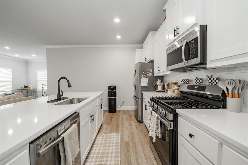 248 Waters Rdg Drive Lavon, TX 75166 - Photo 7 of 36 Kitchen featuring stainless steel appliances, white cabinetry, light wood-style flooring, ornamental molding, and recessed lighting