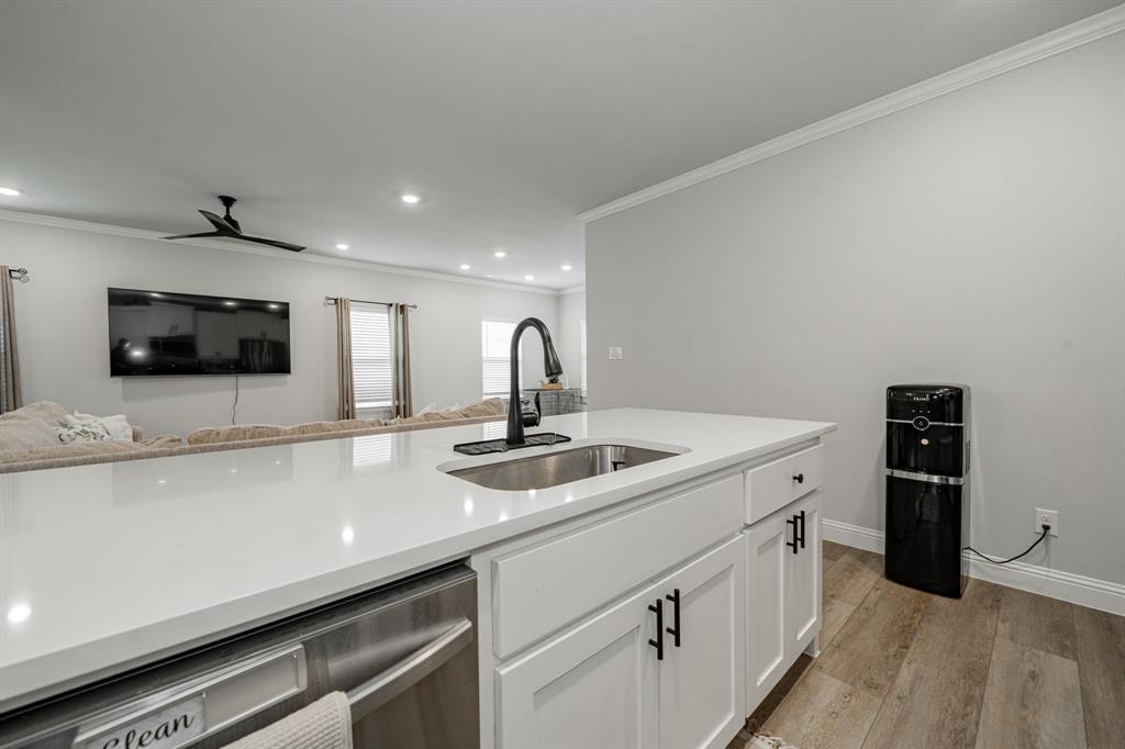 248 Waters Rdg Drive Lavon, TX 75166 - Photo 36 of 36 Kitchen with dishwasher, white cabinetry, ornamental molding, open floor plan, and light wood-style floors