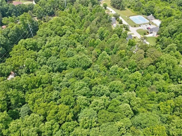 an aerial view of residential house with outdoor space and trees all around