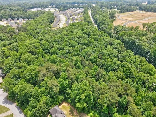a backyard of a house with a lots of plants and small trees