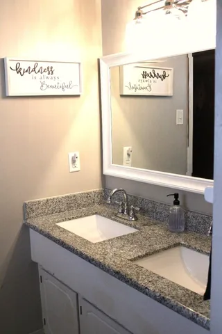 a bathroom with a granite countertop sink and a mirror