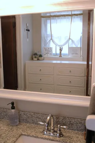 a bathroom with a window sink and mirror