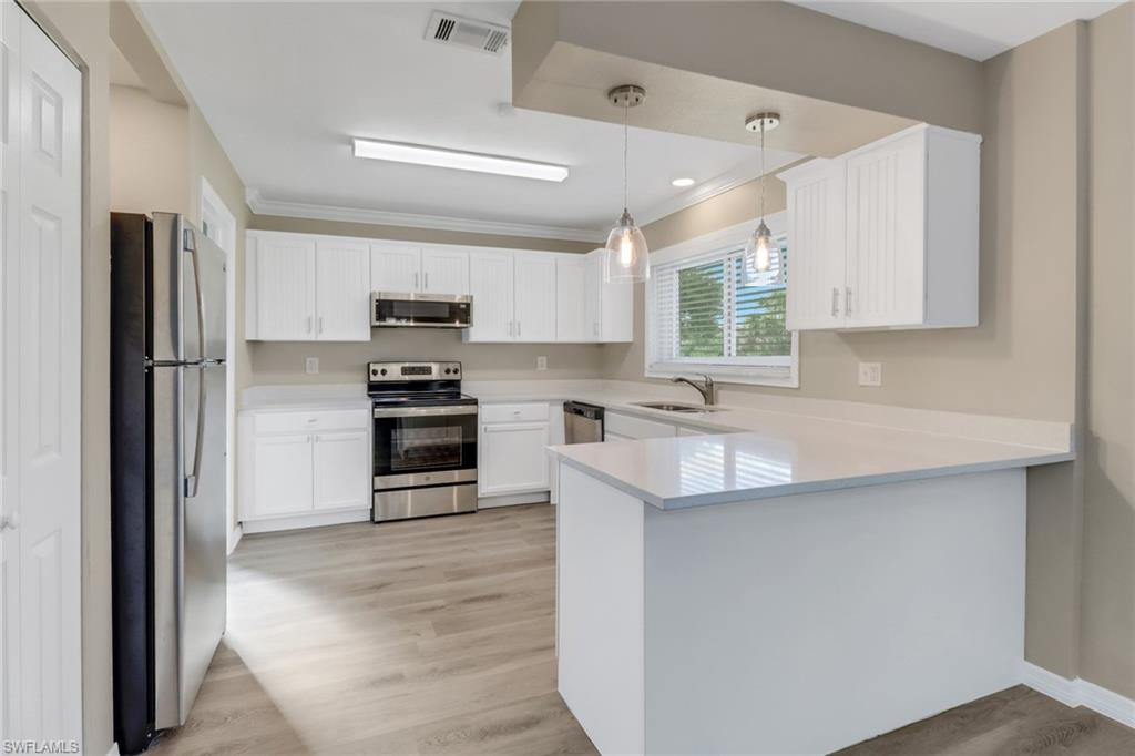4599 Mongite Road North Port, FL 34287 - Photo 9 of 28 a kitchen with kitchen island a sink stainless steel appliances and cabinets