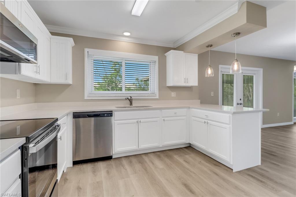 4599 Mongite Road North Port, FL 34287 - Photo 10 of 28 a kitchen with granite countertop white cabinets and white appliances