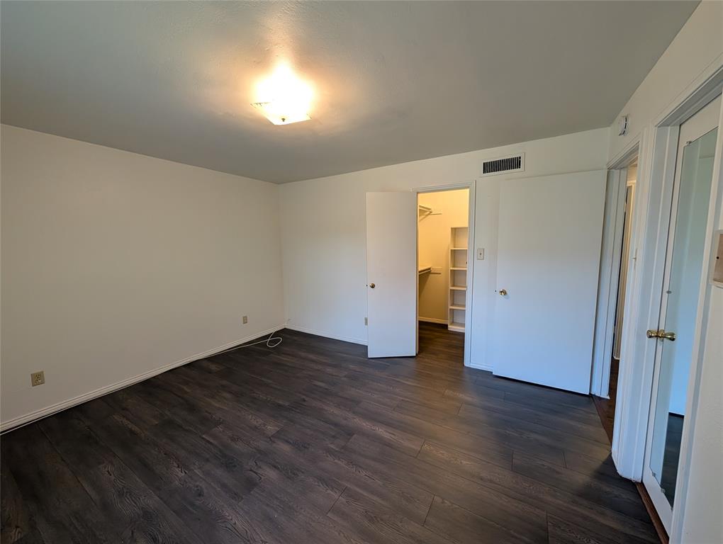 4715 Skillman Street, Unit A Dallas, TX 75206 - Photo 15 of 28 Spacious room featuring dark wood-finish flooring, white baseboards, and a flush-mount ceiling light