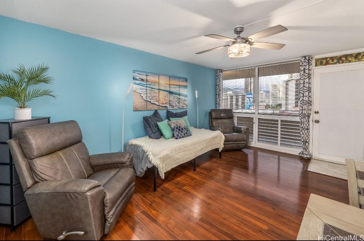 425 Ena Road, Unit 1207B Honolulu, HI 96815 - Photo 2 of 11 a living room with furniture and a wooden floor