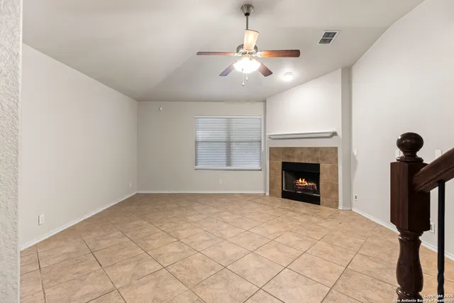 a view of an empty room with a fireplace and a window