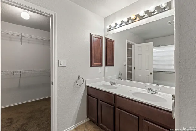 a bathroom with double vanity sinks and a mirror