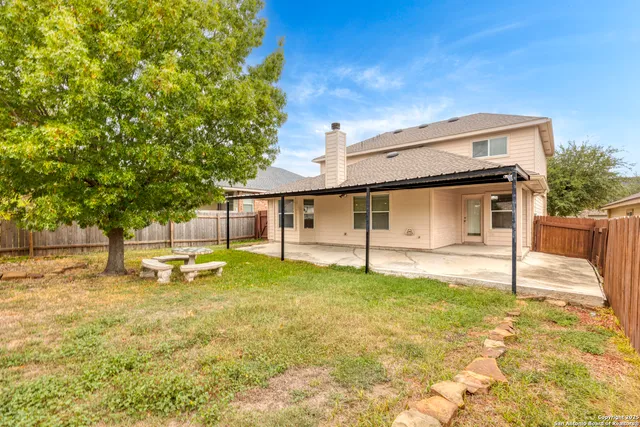 a backyard of a house with table and chairs