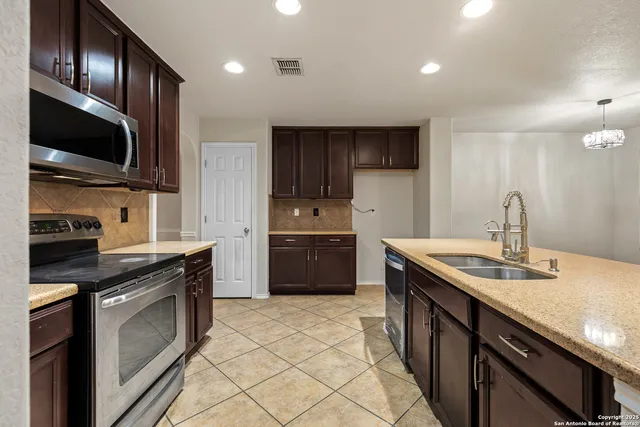 a kitchen with stainless steel appliances granite countertop a sink stove and refrigerator