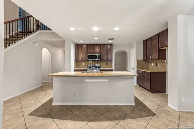 a view of kitchen with stainless steel appliances granite countertop lots of counter top space