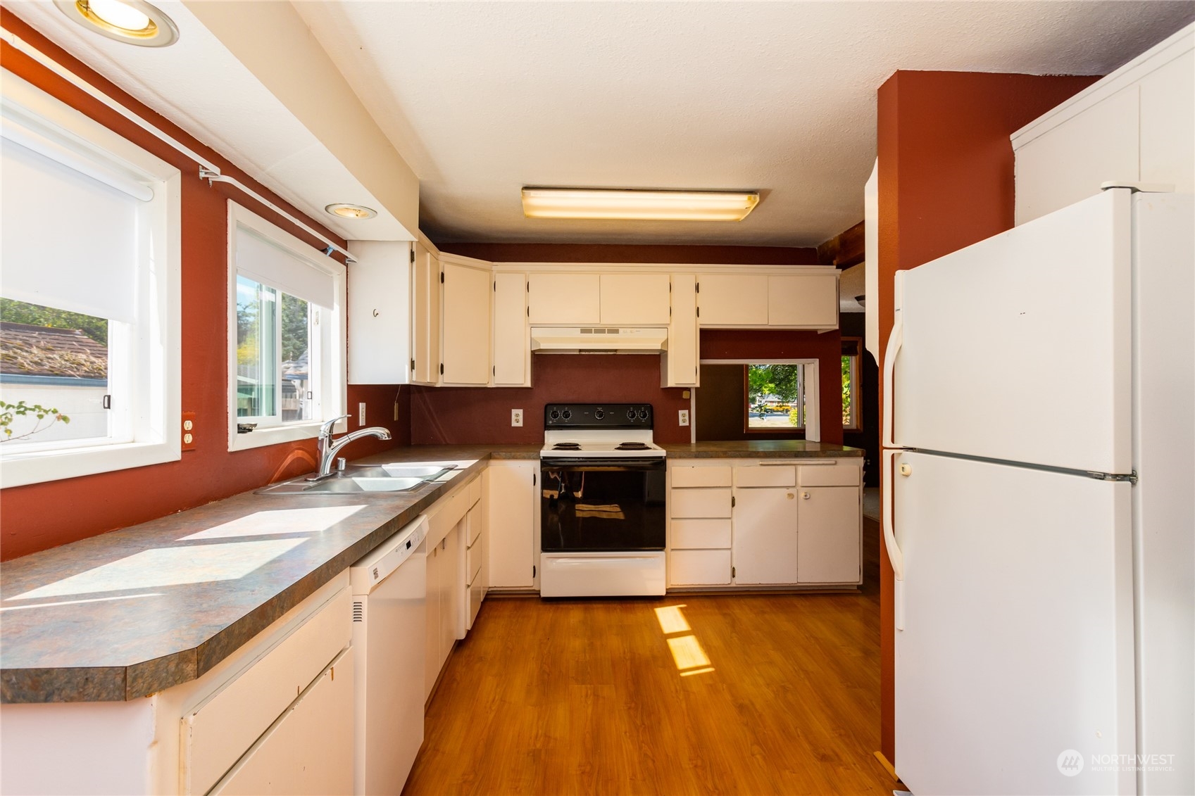 1187 West Axton Road Ferndale, WA 98248 - Photo 14 of 40 a kitchen with a refrigerator a stove top oven a sink and dishwasher with wooden floor