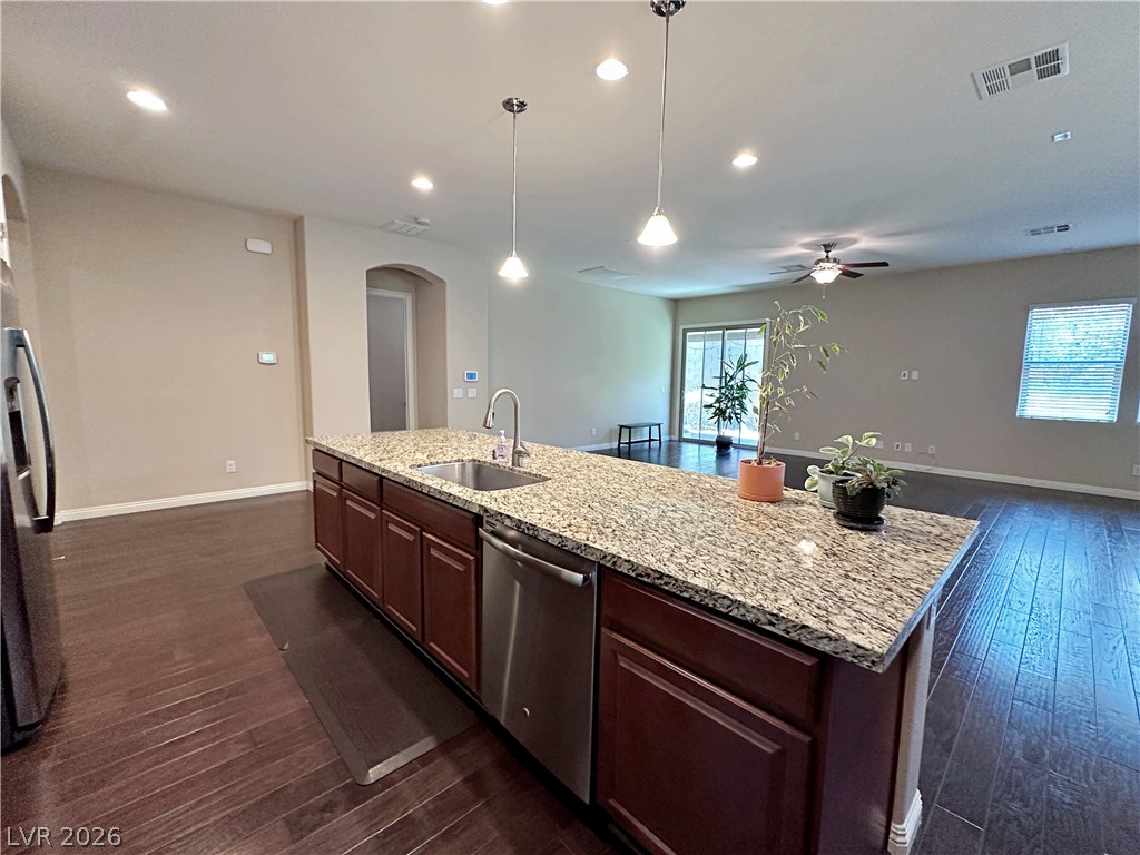 71 Newton Ridge Way Las Vegas, NV 89183 - Photo 16 of 40 A well-appointed kitchen island with granite countertops anchors this luminous open-concept living space.