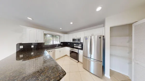 a kitchen with stainless steel appliances granite countertop a refrigerator sink and stove