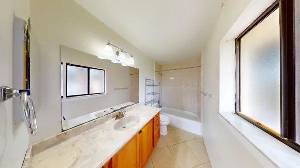 a spacious bathroom with a granite countertop tub sink and mirror