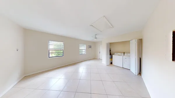 a view of a livingroom with a chandelier fan and windows
