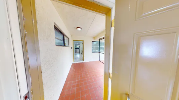 a view of hallway with a bathroom and mirror