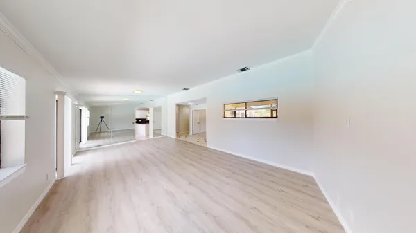 a view of a big room with wooden floor and windows