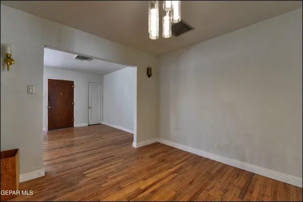 a view of an empty room with wooden floor