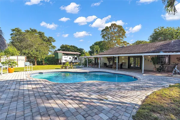 a view of a house with swimming pool and sitting area