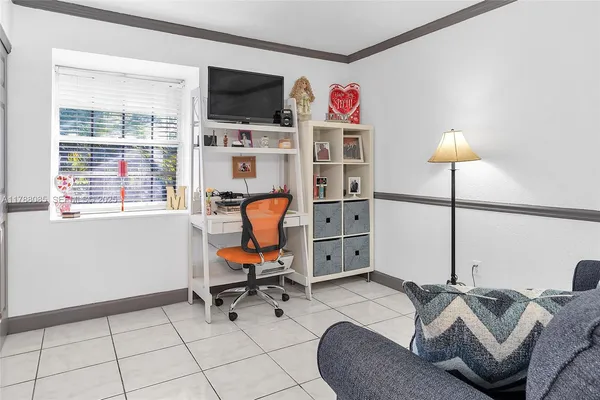 a view of a workspace with furniture and a window
