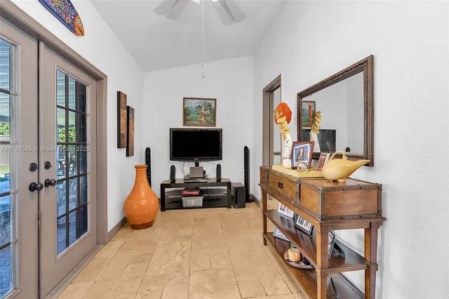 a living room with furniture a flat screen tv and a floor to ceiling window