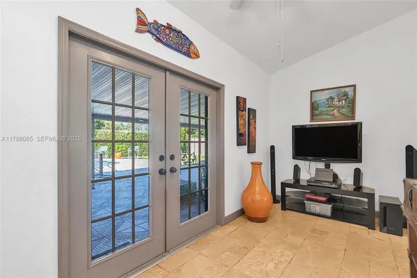 a living room with furniture a flat screen tv and a floor to ceiling window