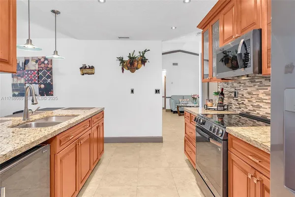 a kitchen with stainless steel appliances granite countertop a sink and a stove