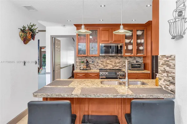 a kitchen with stainless steel appliances granite countertop a sink and a refrigerator