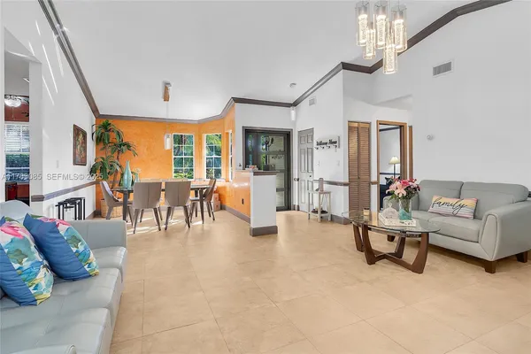 a living room with furniture and a chandelier