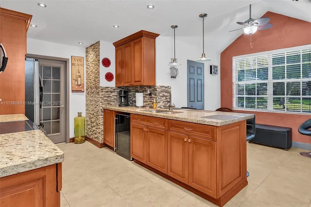 a kitchen with stainless steel appliances granite countertop a stove a sink and a refrigerator