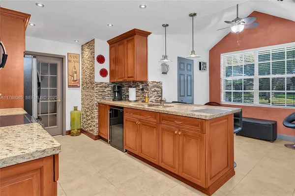 a kitchen with stainless steel appliances granite countertop a stove a sink and a refrigerator