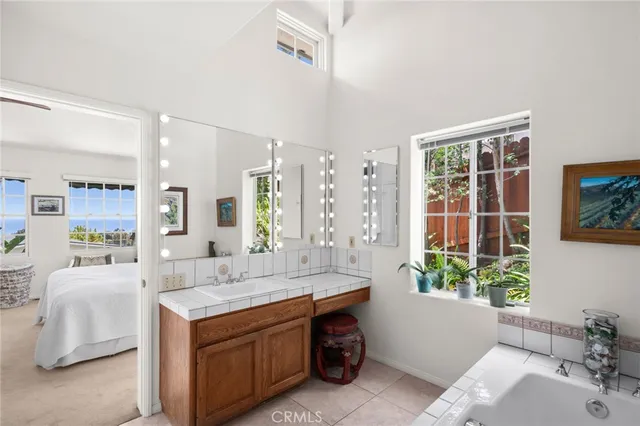 a spacious bathroom with a tub sink and mirror
