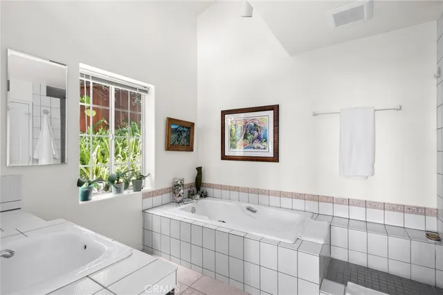 a bathroom with a tub a sink and a window