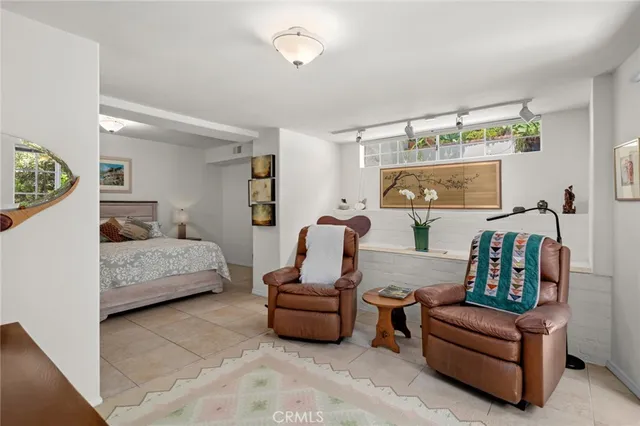 a view of a white house with a small yard and potted plants